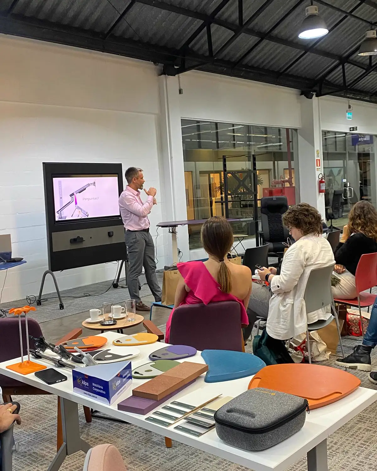 Cristiano Assis, da Octoo, apresentando suportes e acessórios ergonômicos no showroom da Klips