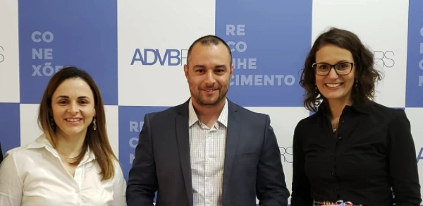 Cristiano ao lado de duas pessoas em evento da ADVB