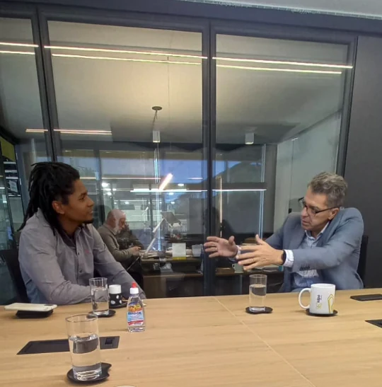 Conversa entre dois profissionais em uma mesa de reunião